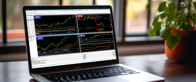 Un portátil que muestra pantallas de negociación de divisas con operadores analizando datos para realizar análisis financieros.