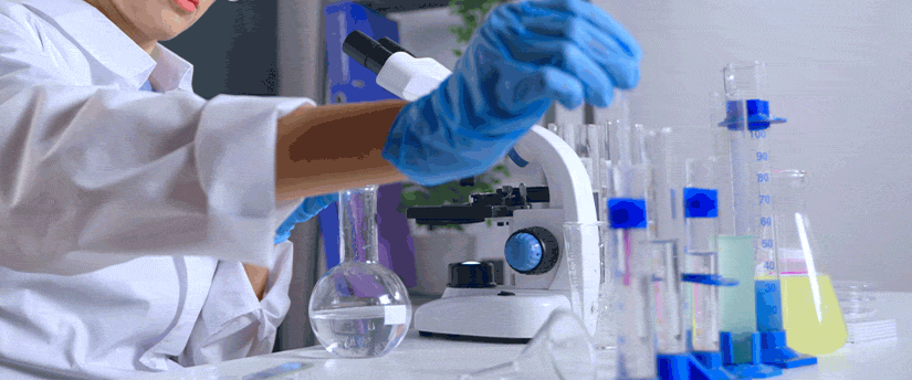 A woman wearing a lab coat is conducting an experiment with a test tube, showcasing her dedication to scientific inquiry.