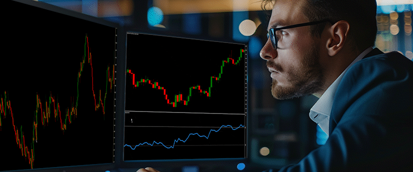 Side view of a focused male forex trader reviewing live market data on a screen to understand how to calculate pips in forex.
