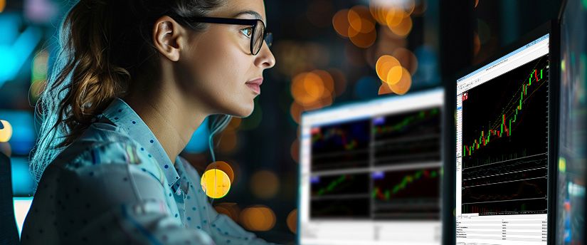 Female financial analyst examining trading software monitors while studying how to calculate pips in forex.